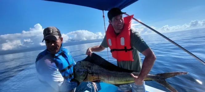 Proud fisherman holding large marlin on deck